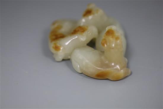A Chinese pale celadon and russet jade group of three goats, 19th/20th century, 5cm, wood stand